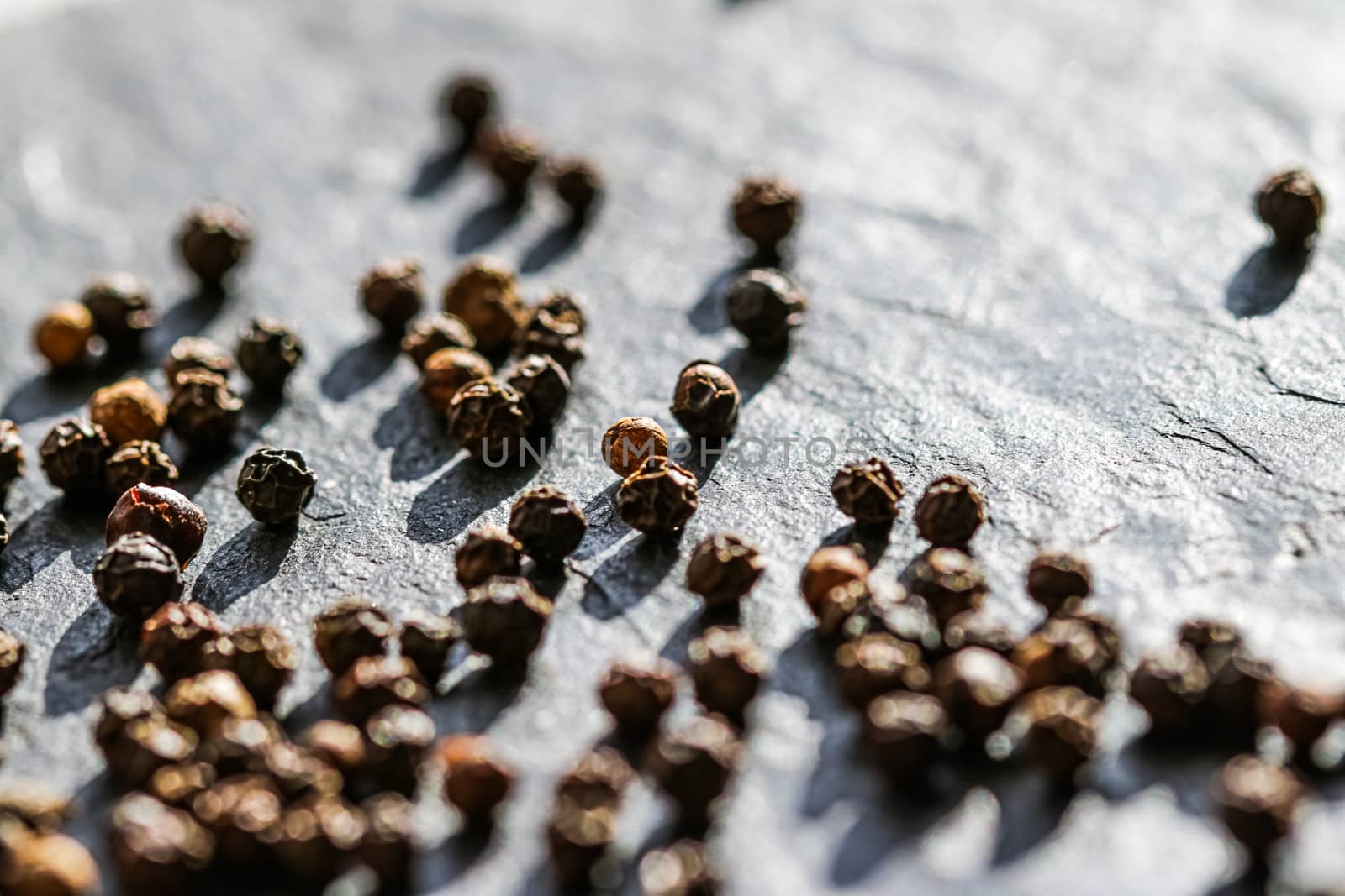 Black pepper closeup on luxury stone background as flat lay, dry food spices and recipe ingredients