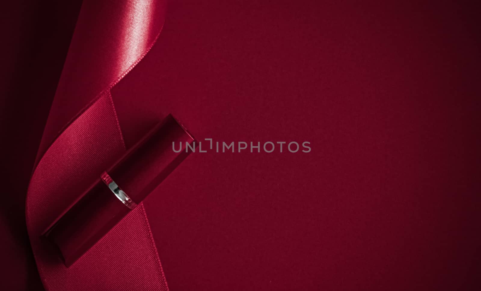 Cosmetic branding, glamour lip gloss and shopping sale concept - Luxury lipstick and silk ribbon on maroon holiday background, make-up and cosmetics flatlay for beauty brand product design