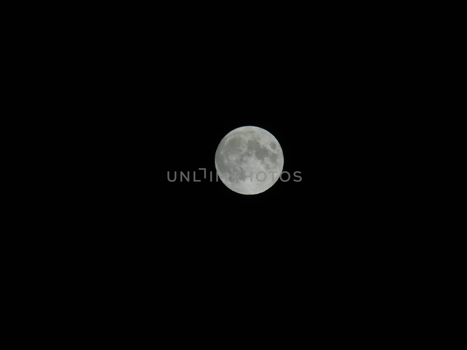 An amazing photography of the full moon over the city of Genova by night with a great clear sky in background and some stars