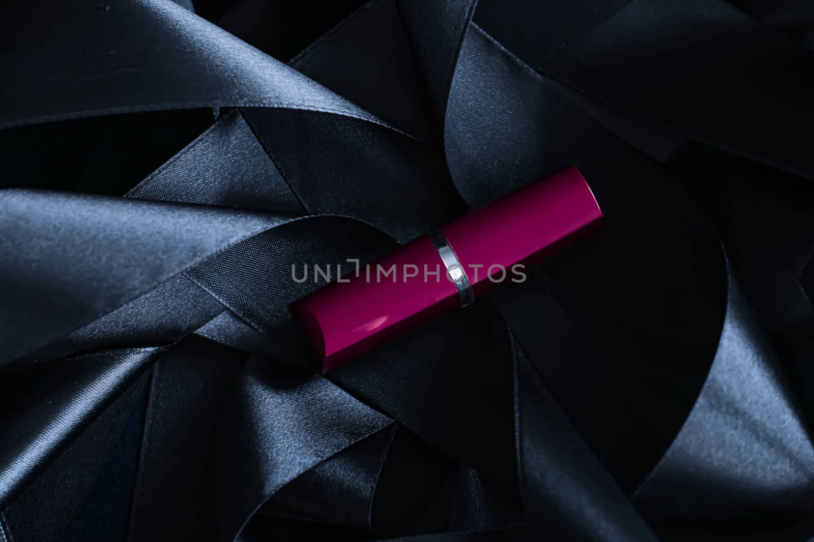 Purple lipstick on black silk background, luxury make-up and beauty cosmetics