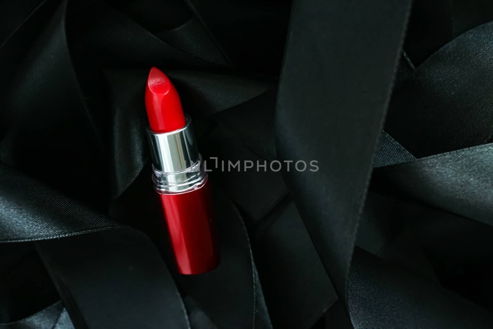 Red lipstick on black silk background, luxury make-up and beauty by Anneleven