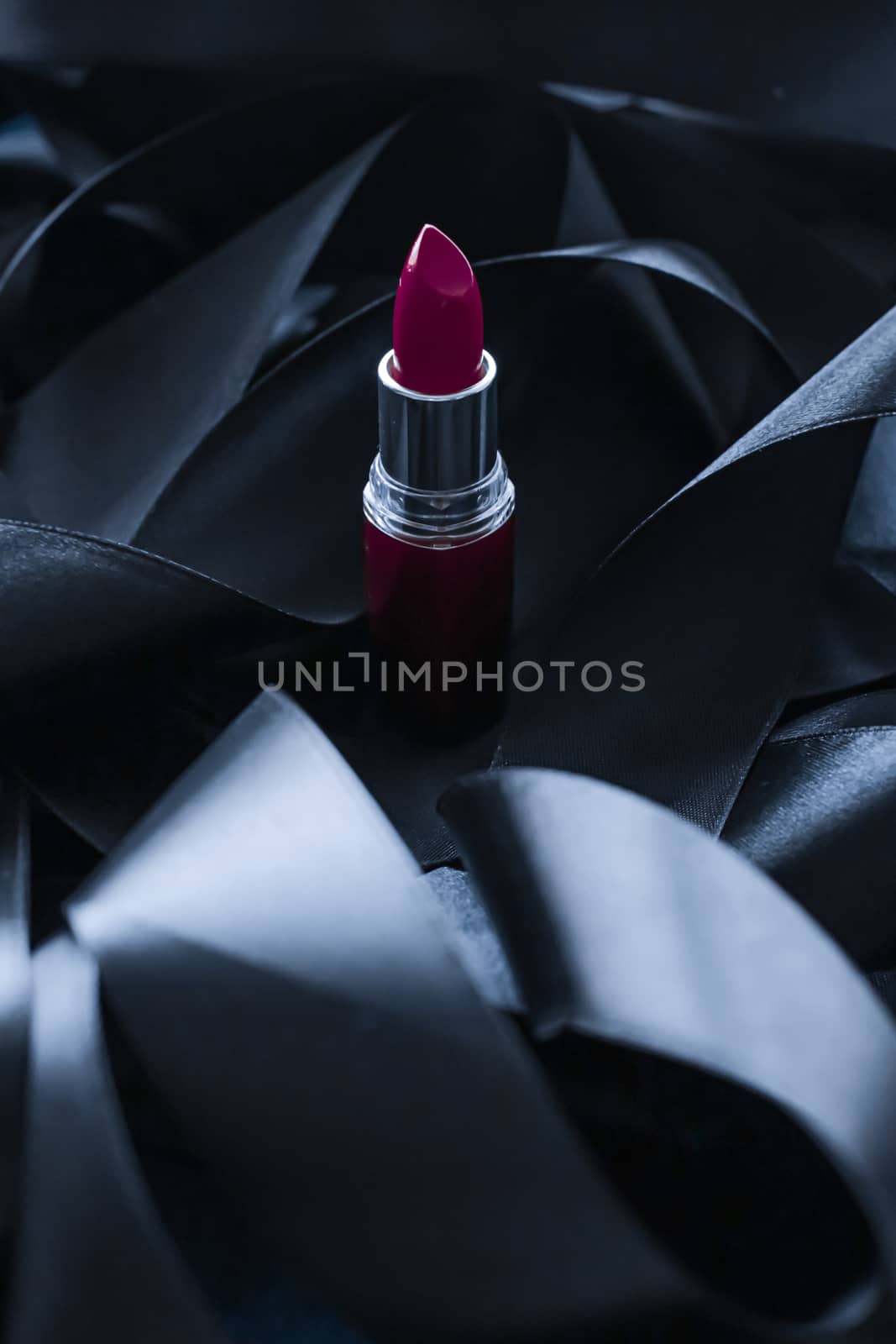 Purple lipstick on black silk background, luxury make-up and beauty cosmetics