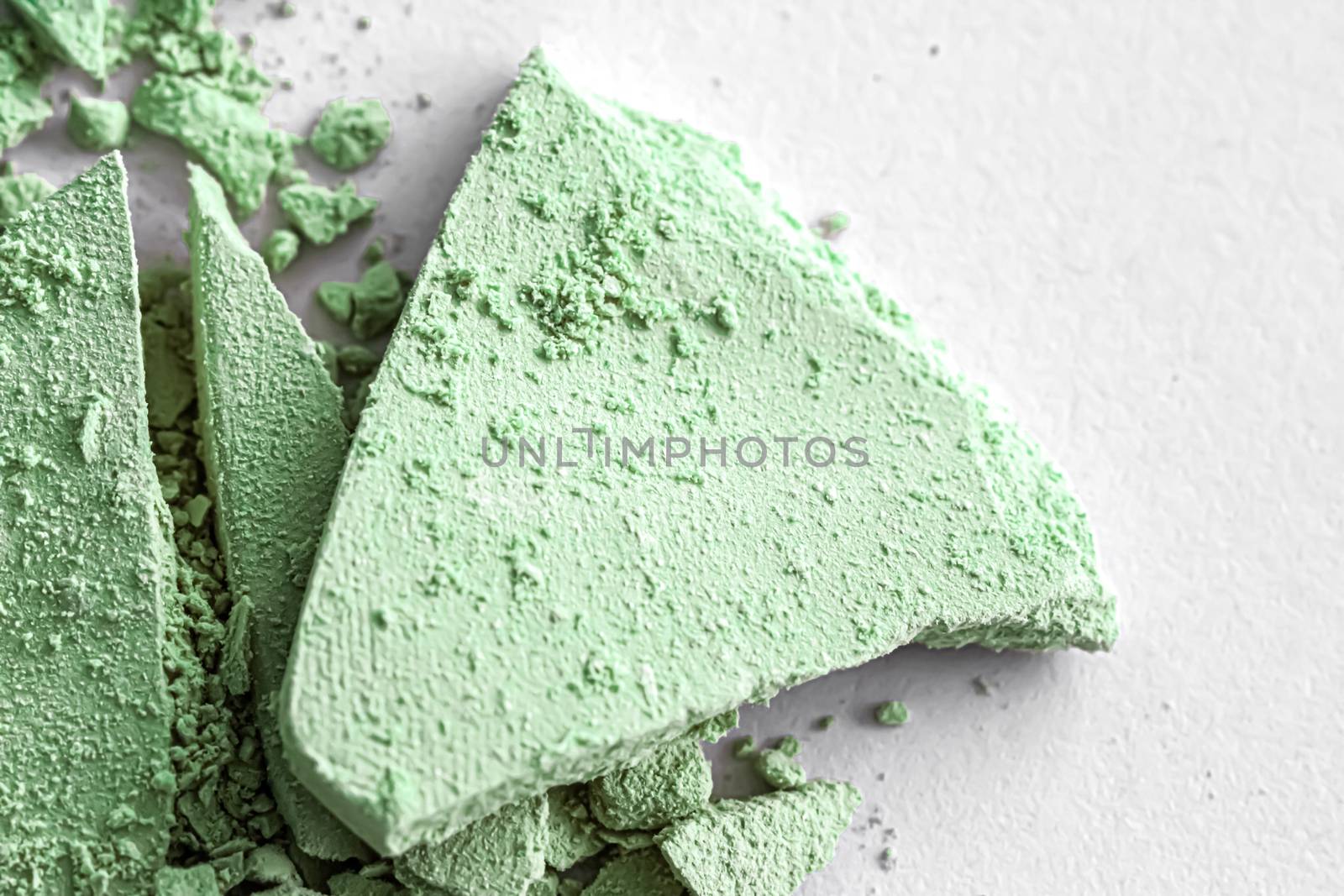 Green eye shadow powder as makeup palette closeup isolated on white background, crushed cosmetics and beauty textures