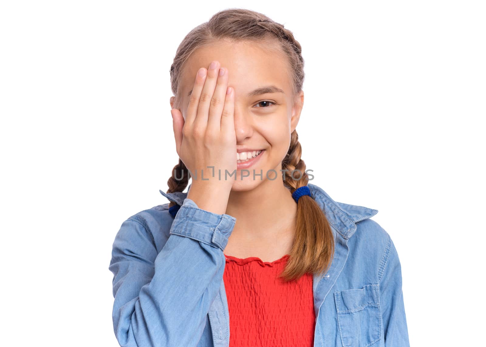 Happy teenage girl looks with one eye while covering his other eye with his hand, isolated on white background