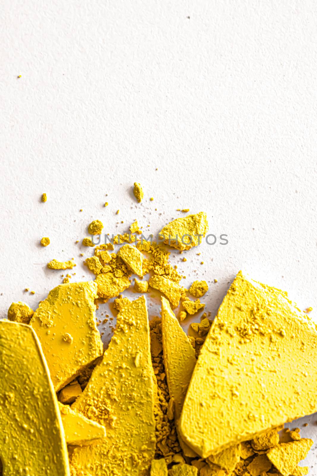 Yellow eye shadow powder as makeup palette closeup isolated on white background, crushed cosmetics and beauty textures