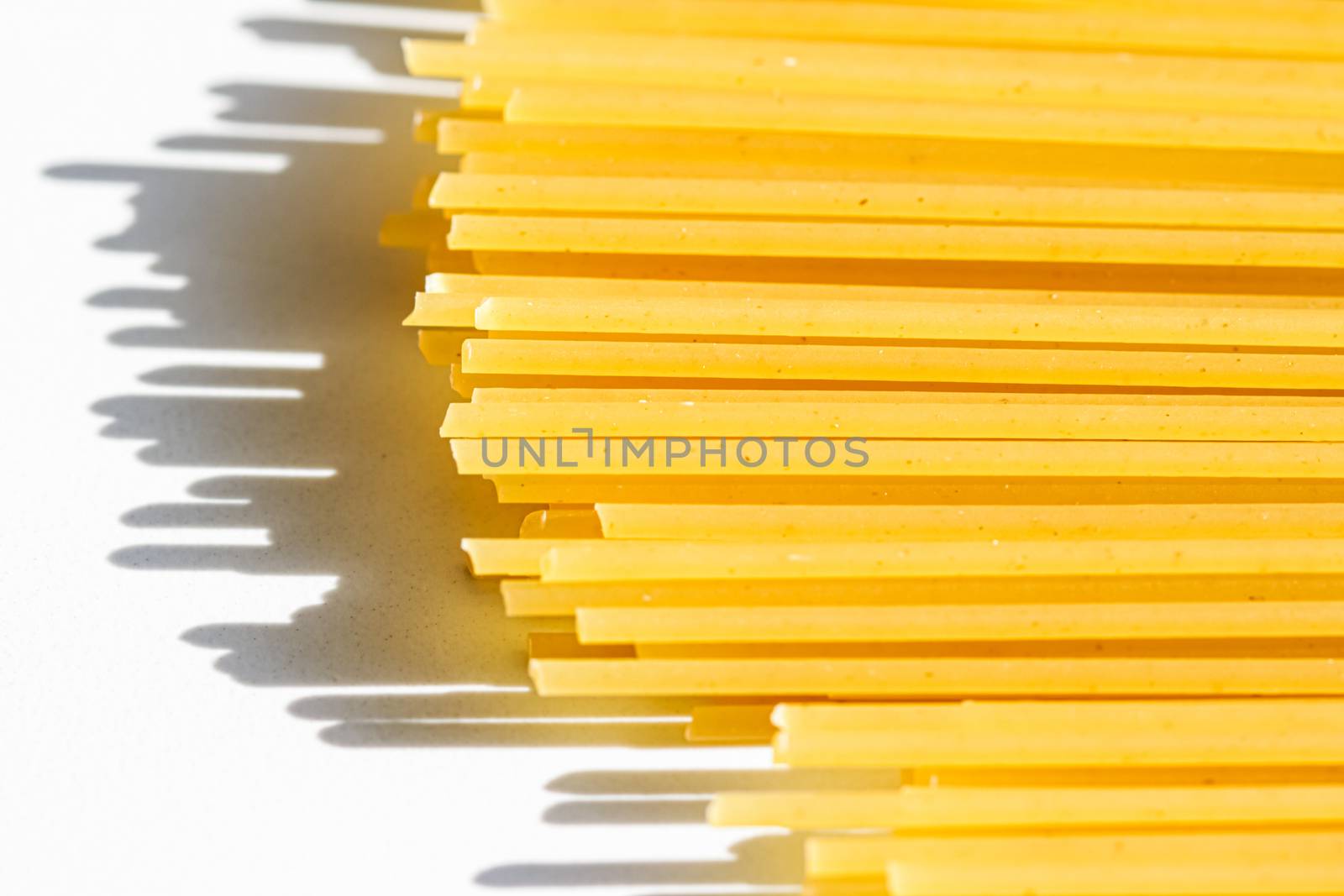 Uncooked whole grain spaghetti closeup, italian pasta as organic food ingredient, macro product and cook book recipes