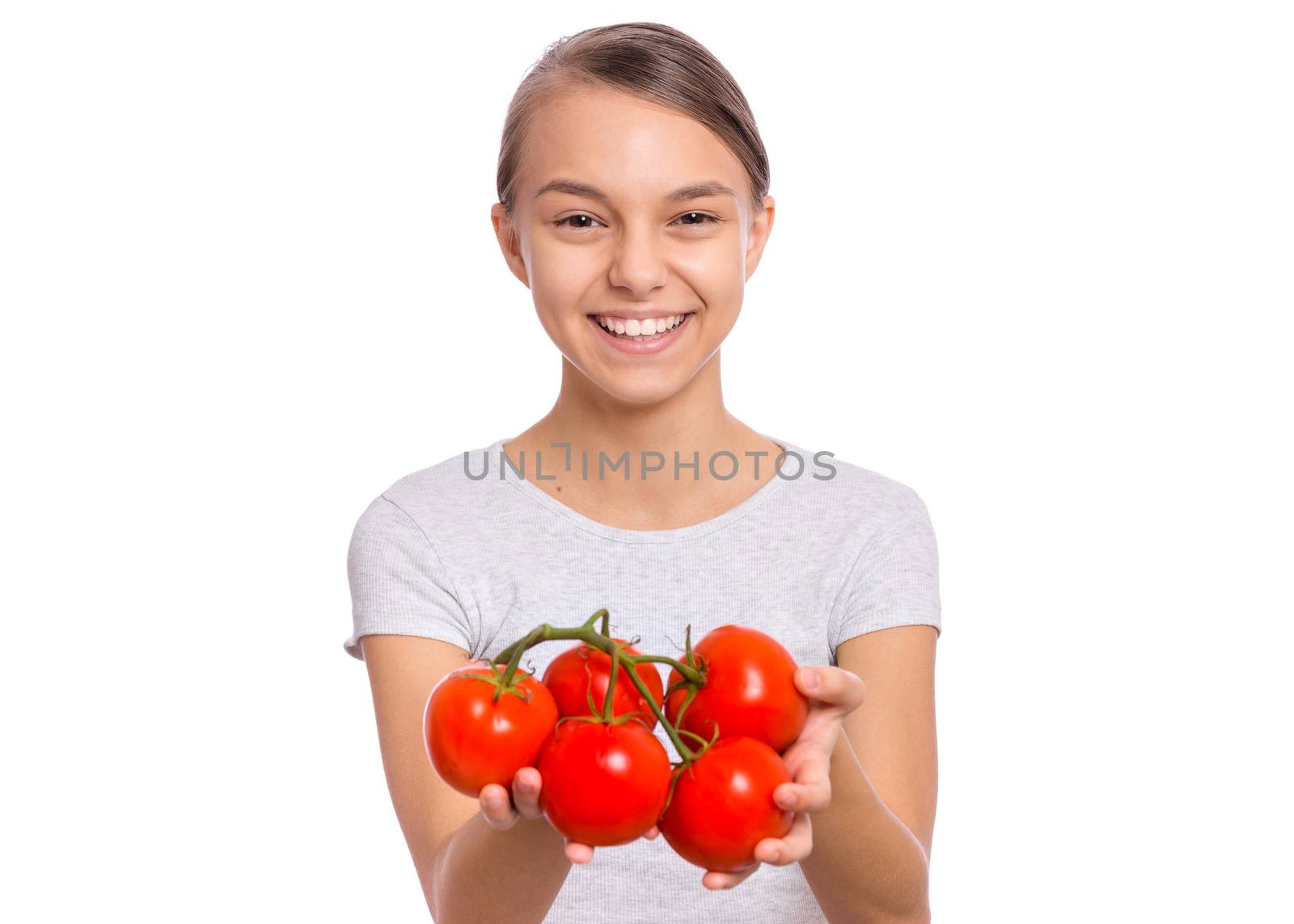 Beautiful young teen girl holding fresh tomatoes, isolated on white background