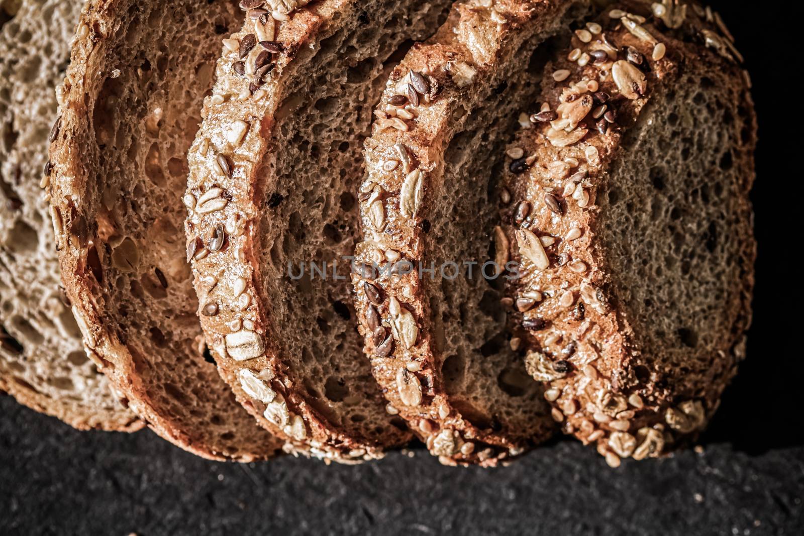 Fresh whole grain seeded bread, organic wheat flour, closeup slice texture as background for food blog or cook book recipes