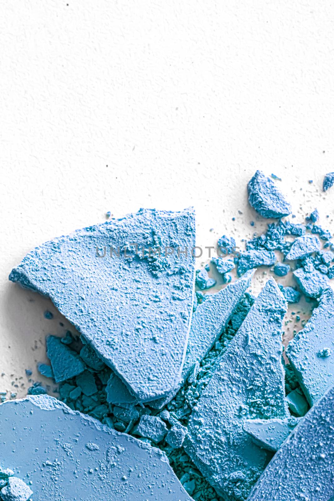 Blue eye shadow powder as makeup palette closeup isolated on white background, crushed cosmetics and beauty textures