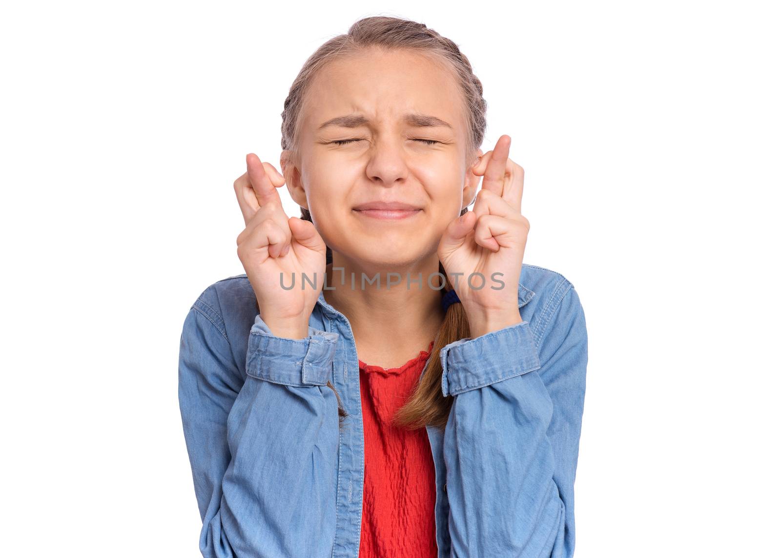 Happy teenage girl looking very happy holding fingers crossed for good luck, isolated on white background