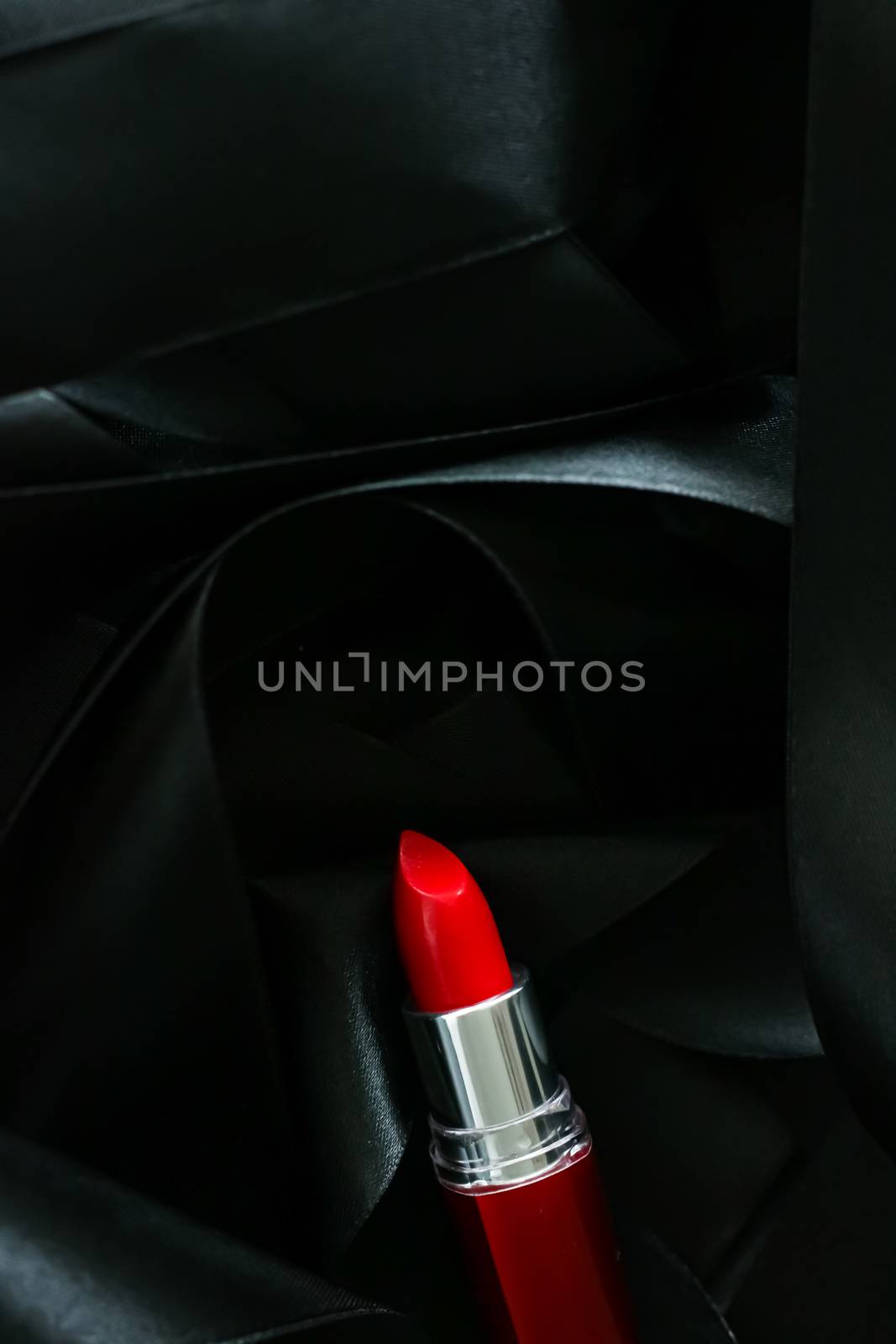 Red lipstick on black silk background, luxury make-up and beauty cosmetics