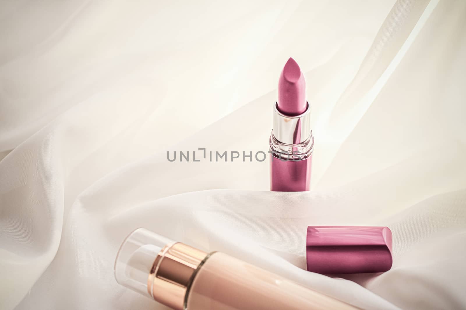 Cosmetic branding, glamour and skincare concept - Beige tonal cream bottle make-up fluid foundation base and pink lipstick on silk background, cosmetics products as luxury beauty brand holiday design