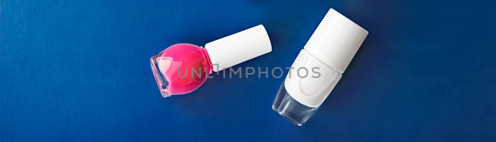 Nail polish bottles on dark blue background, beauty branding