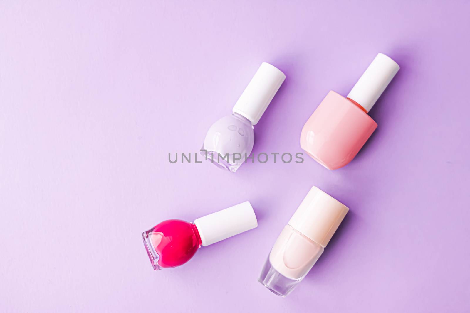 Nail polish bottles on purple background, beauty brand by Anneleven