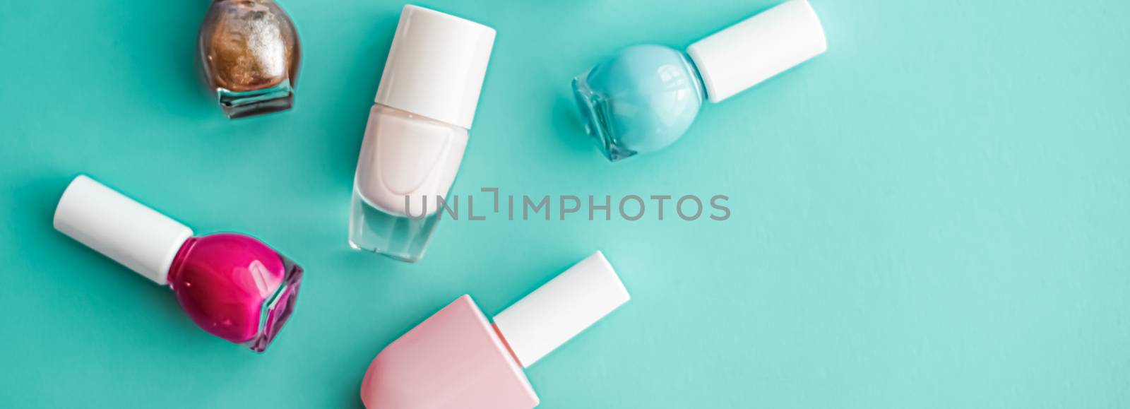 Nail polish bottles on green background, beauty branding