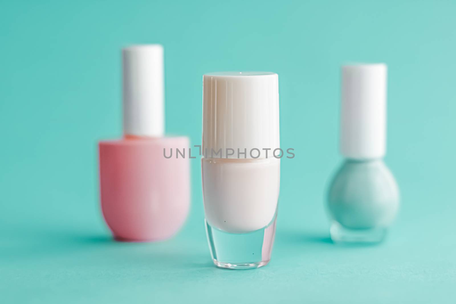 Nail polish bottles on green background, beauty branding