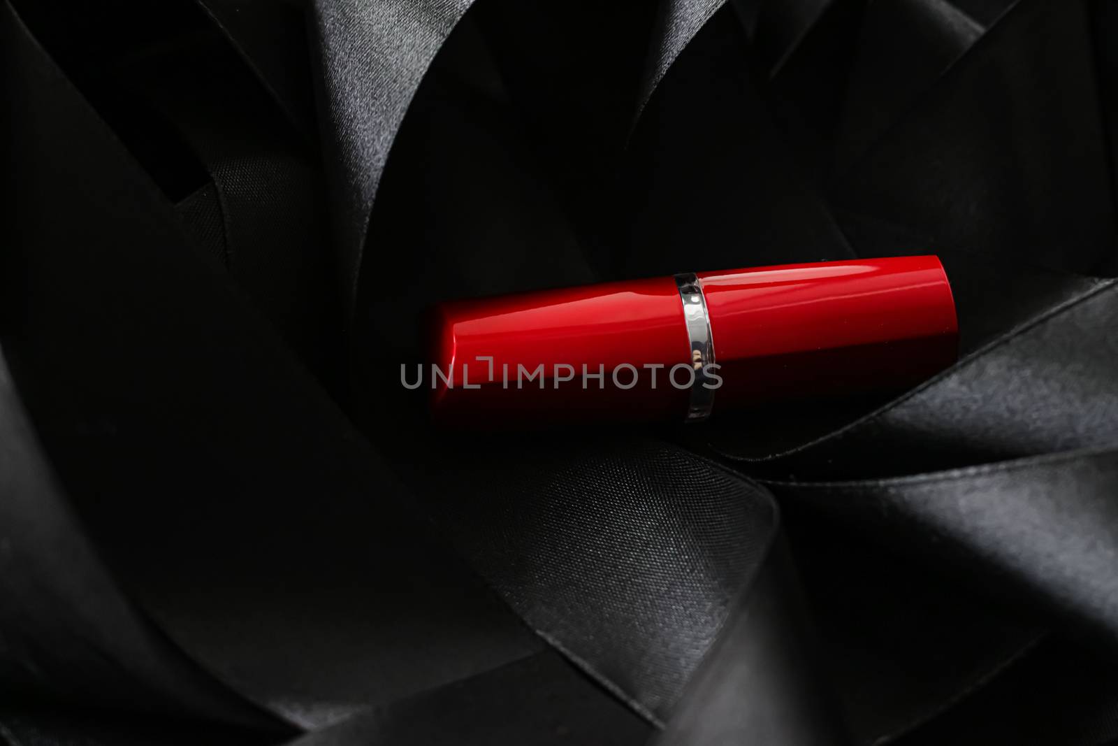 Red lipstick on black silk background, luxury make-up and beauty cosmetics