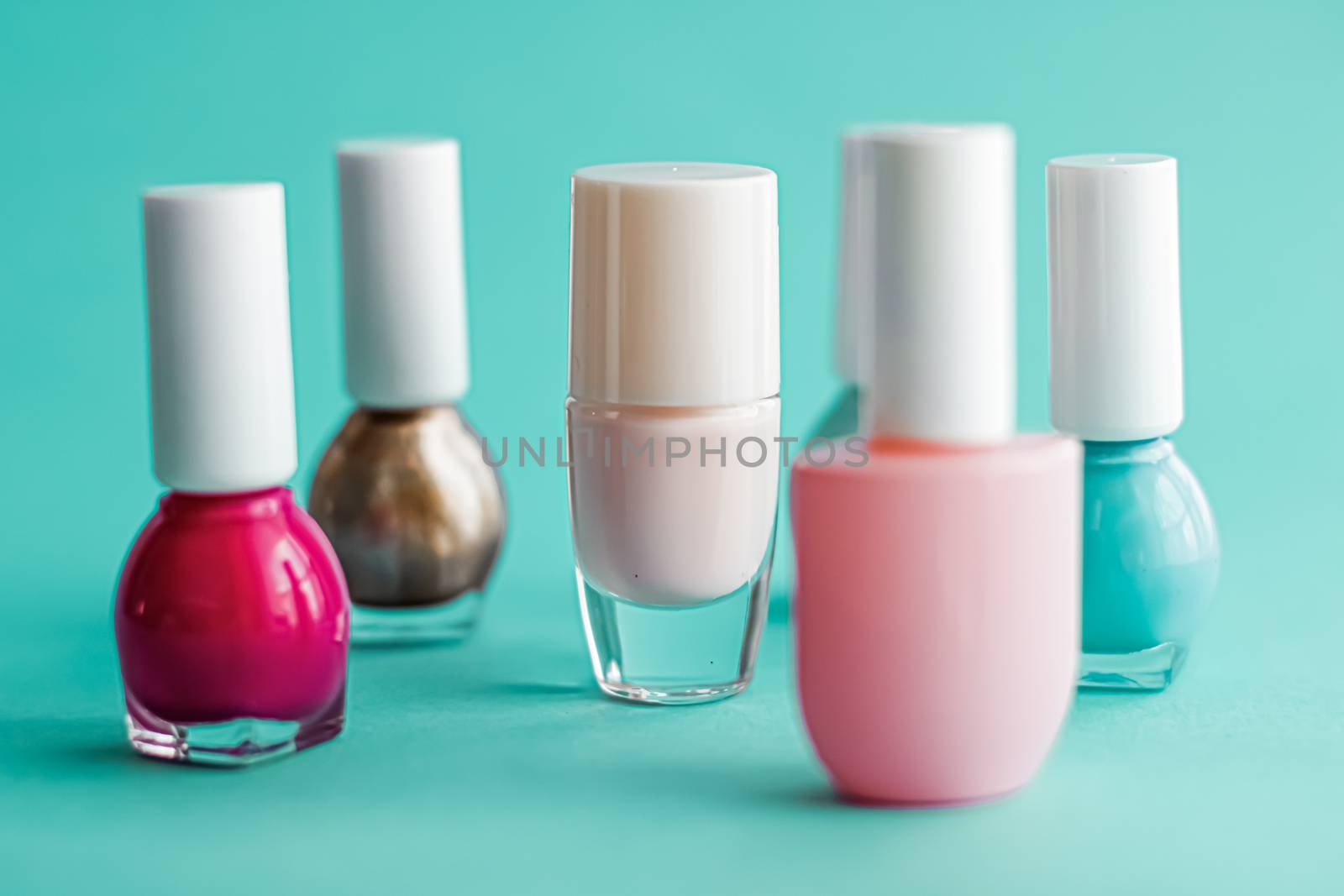 Nail polish bottles on green background, beauty branding