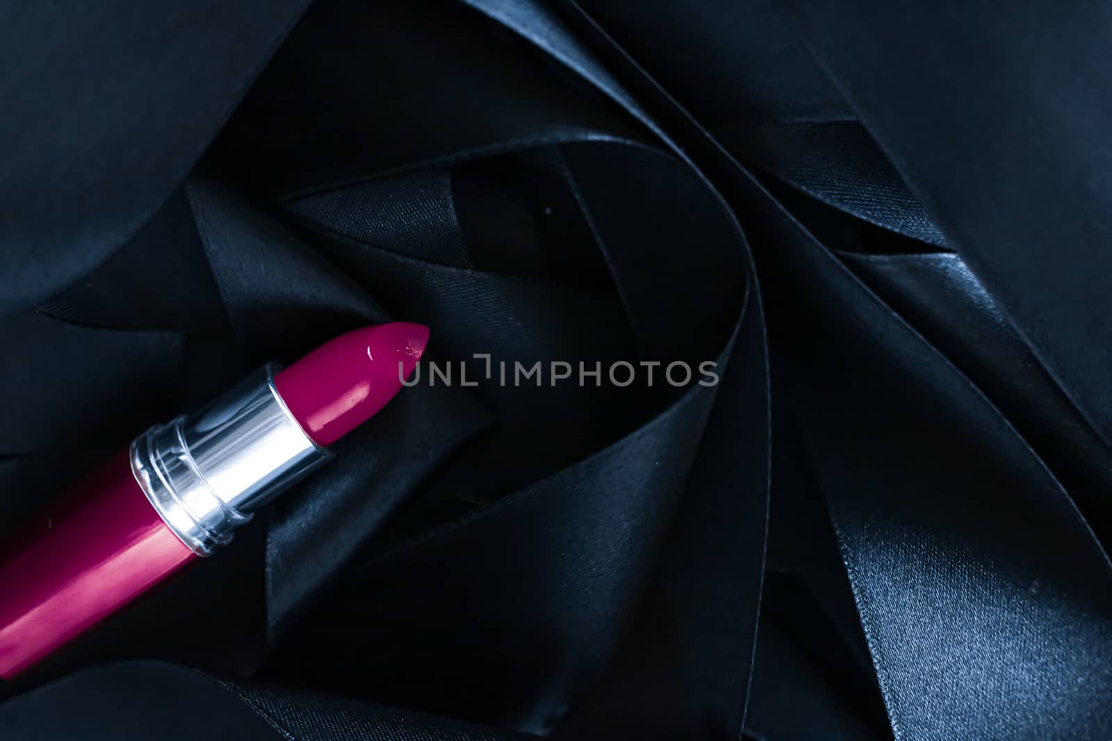 Purple lipstick on black silk background, luxury make-up and beauty cosmetics