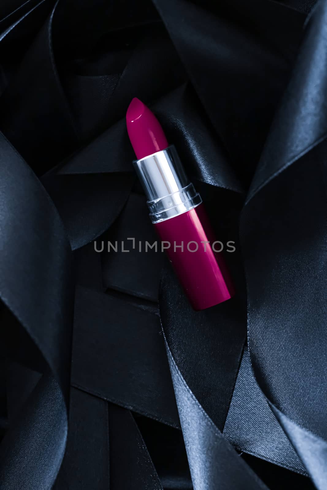 Purple lipstick on black silk background, luxury make-up and beauty cosmetics