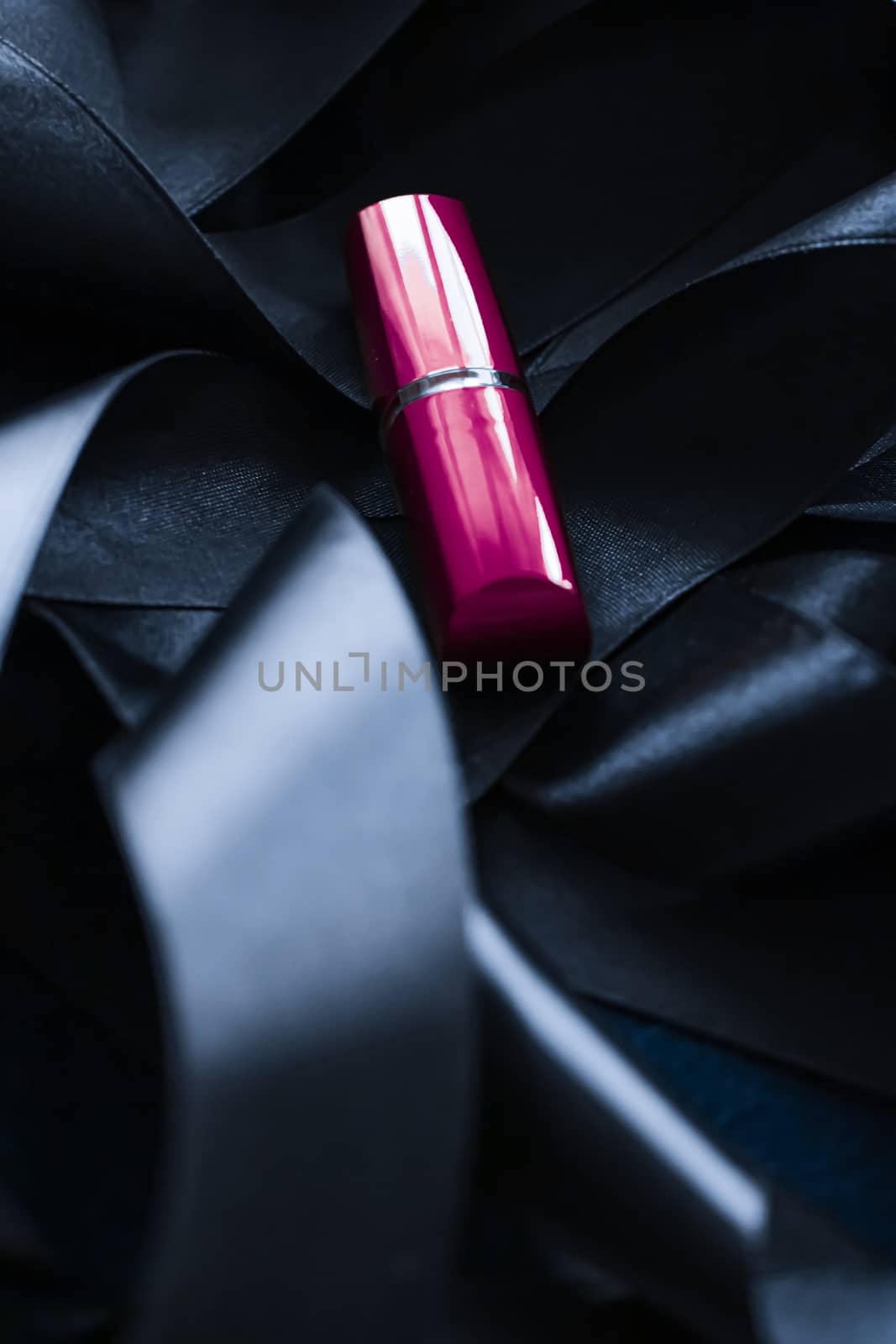 Purple lipstick on black silk background, luxury make-up and beauty cosmetics