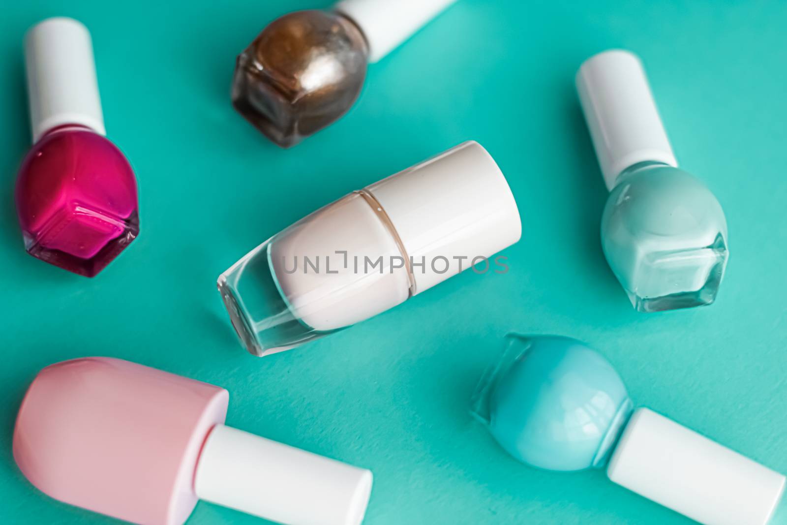 Nail polish bottles on green background, beauty branding