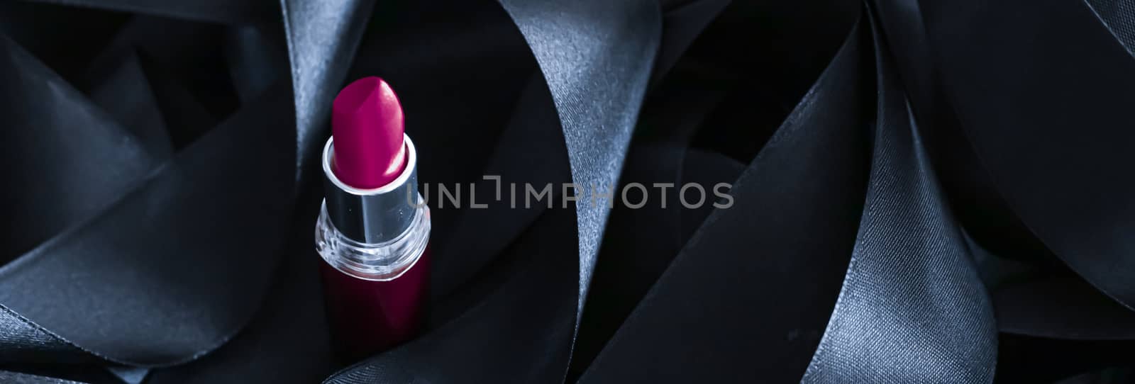 Purple lipstick on black silk background, luxury make-up and beauty cosmetics