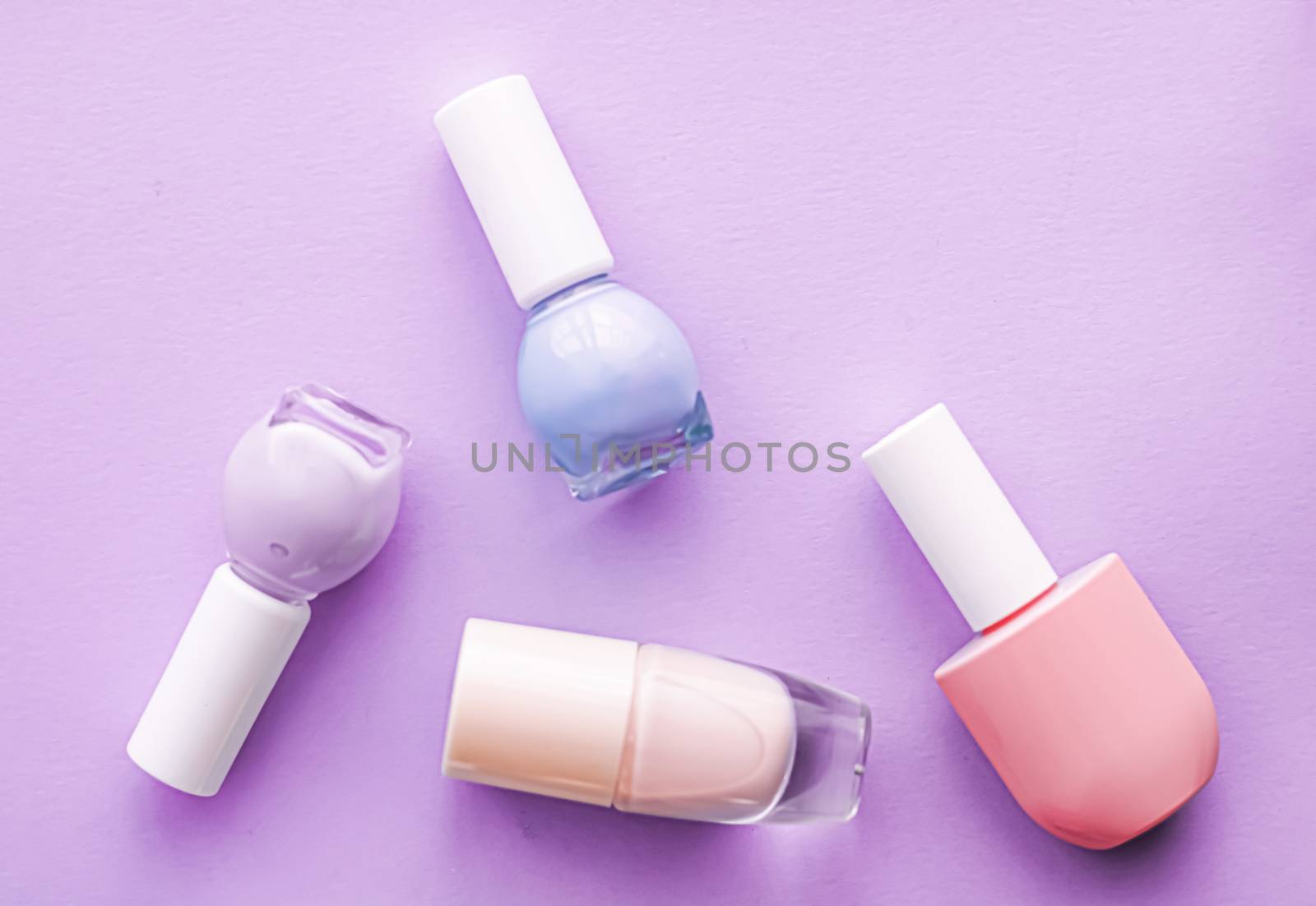 Nail polish bottles on purple background, beauty branding