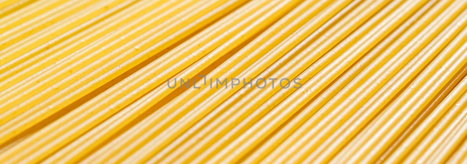 Uncooked whole grain spaghetti closeup, italian pasta as organic food ingredient, macro product and cook book recipes