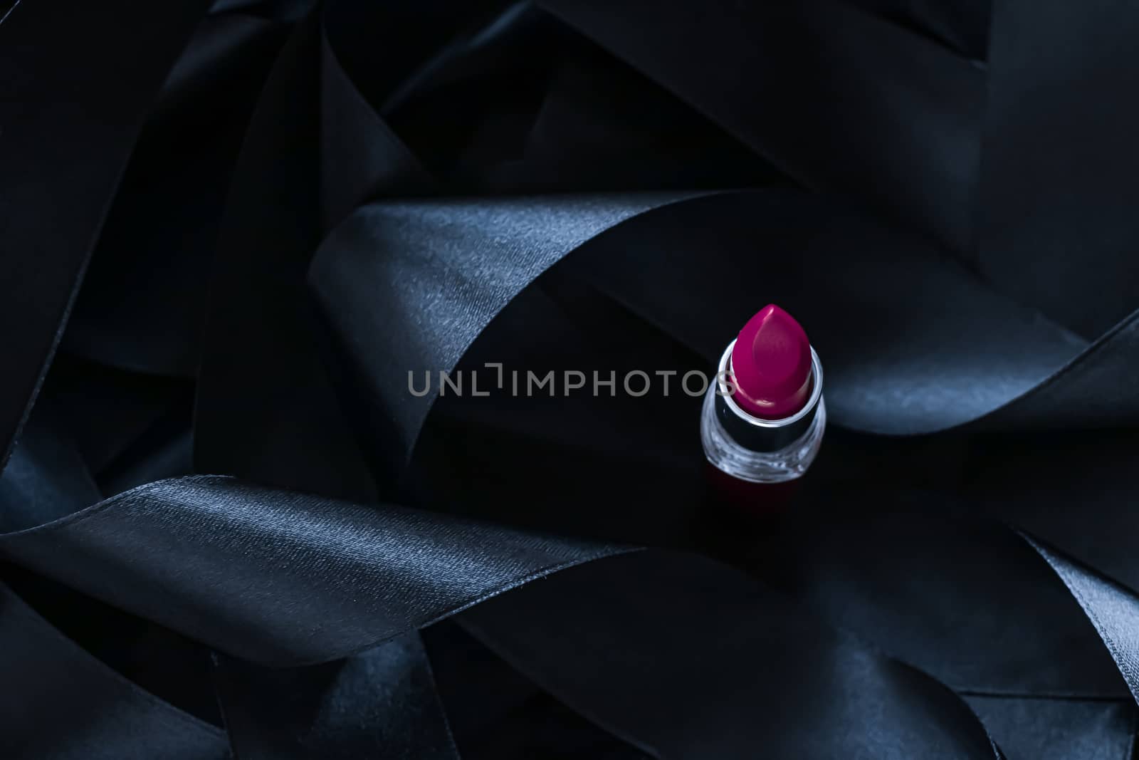 Purple lipstick on black silk background, luxury make-up and beauty cosmetics