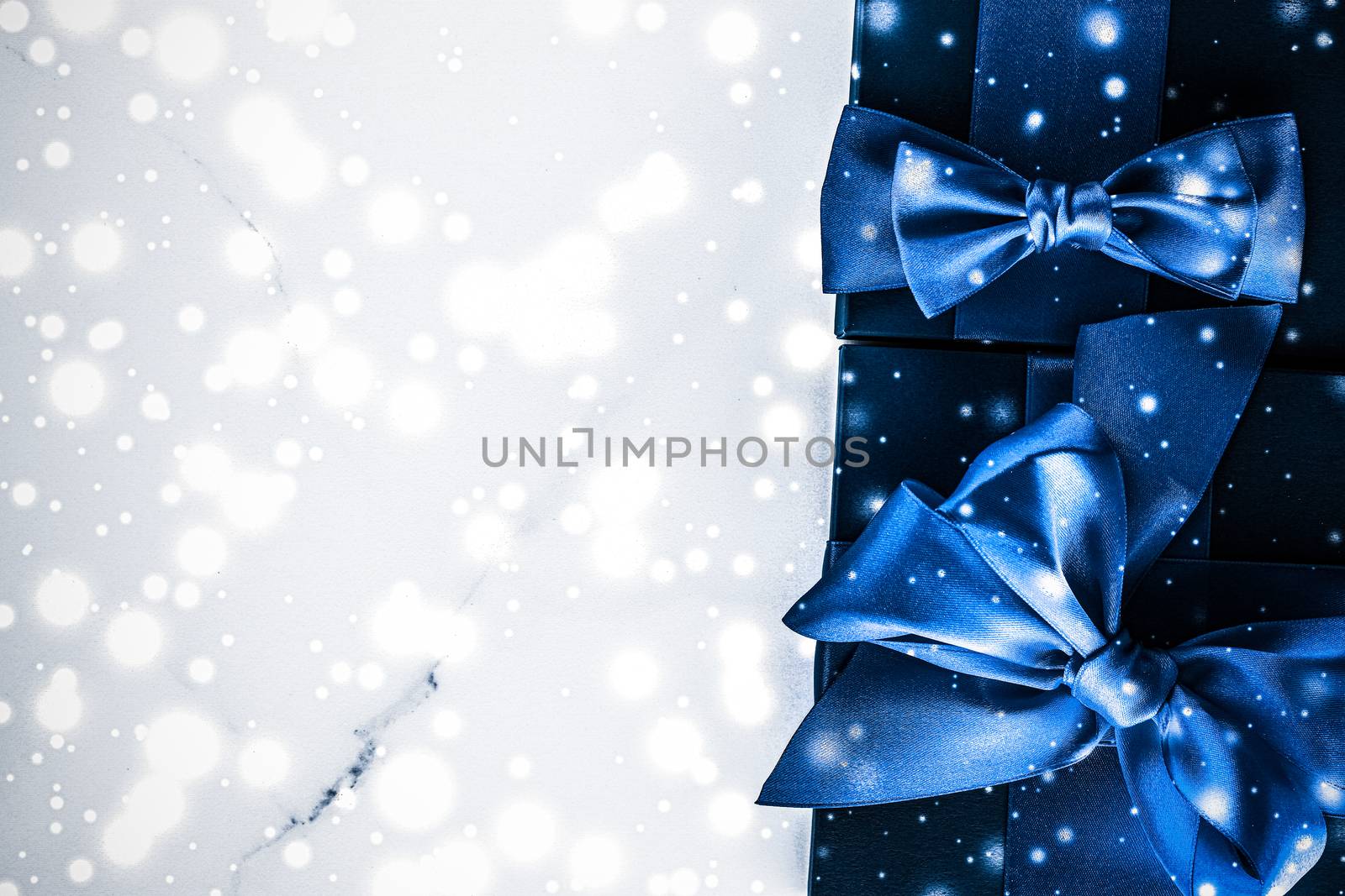 Winter holiday gift box with blue silk bow, snow glitter on marb by Anneleven