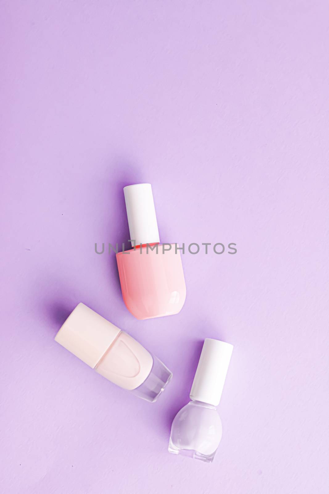 Nail polish bottles on purple background, beauty branding