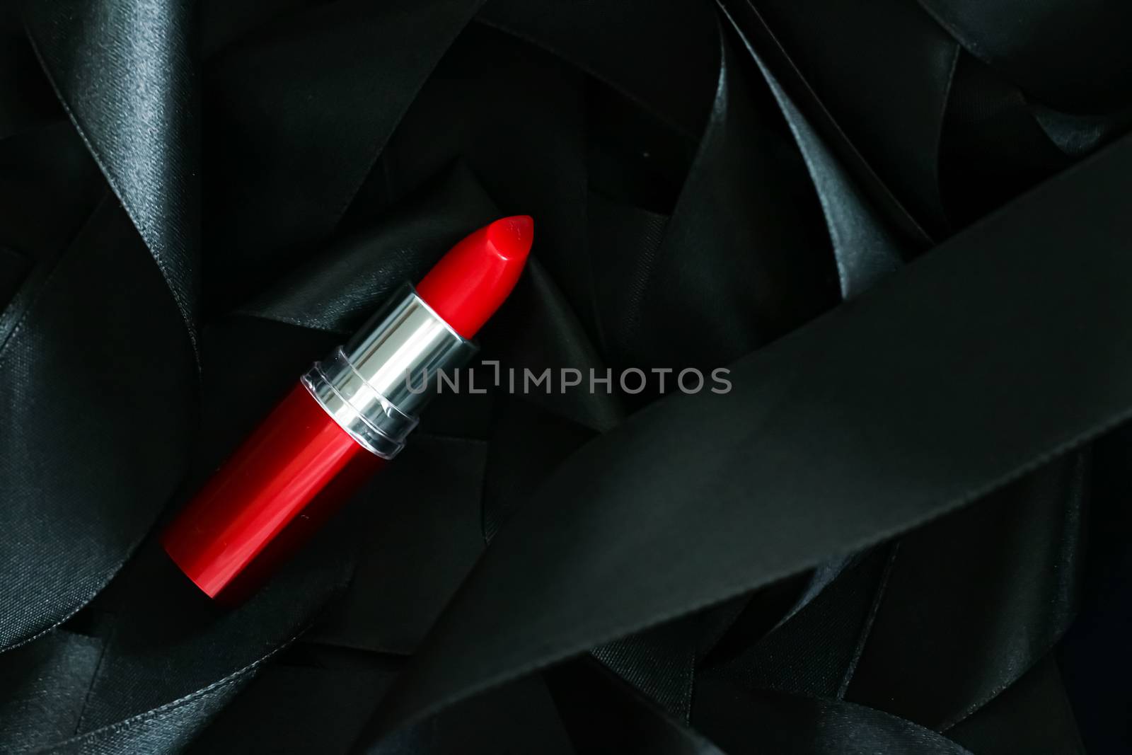 Red lipstick on black silk background, luxury make-up and beauty by Anneleven