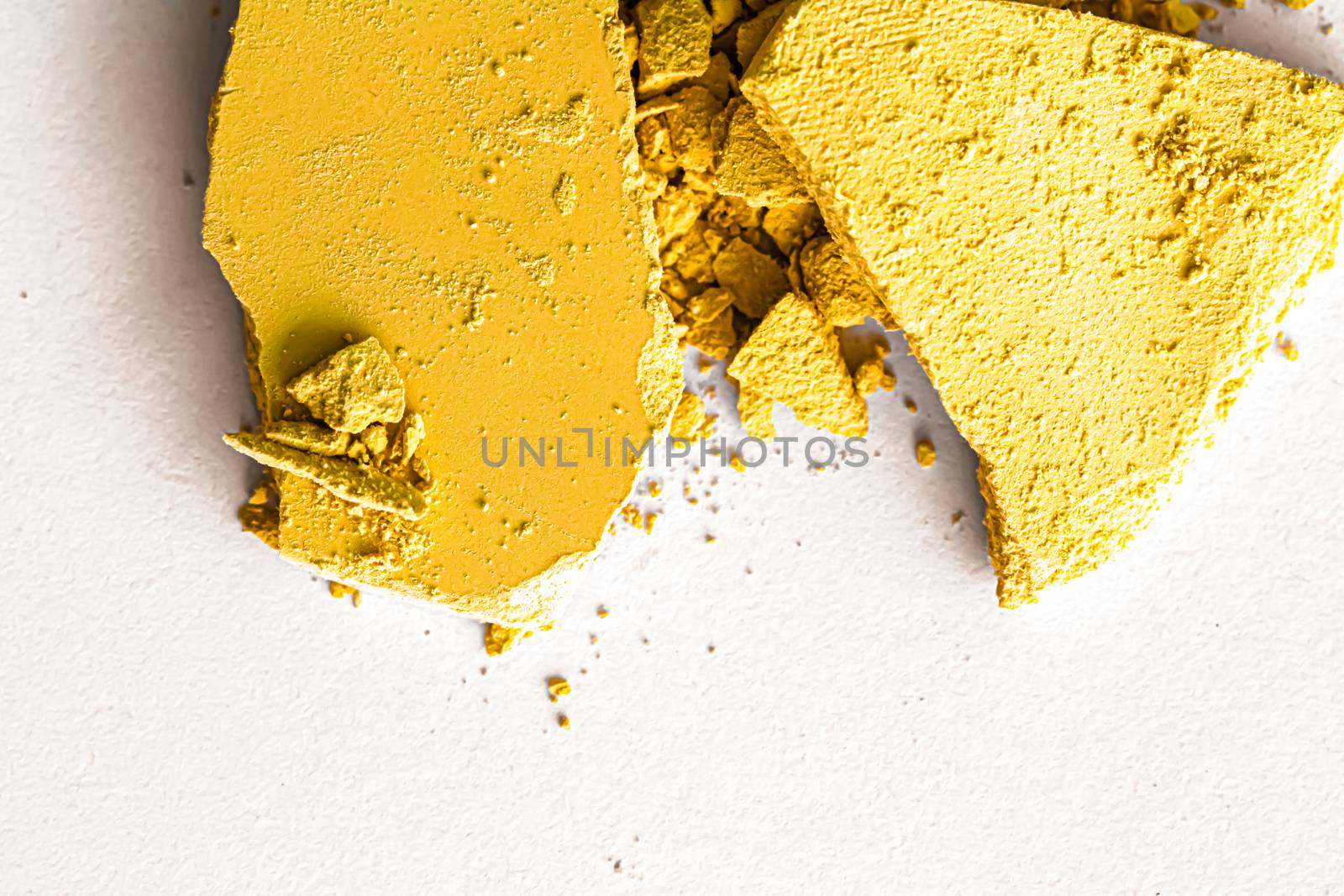 Yellow eye shadow powder as makeup palette closeup isolated on white background, crushed cosmetics and beauty textures