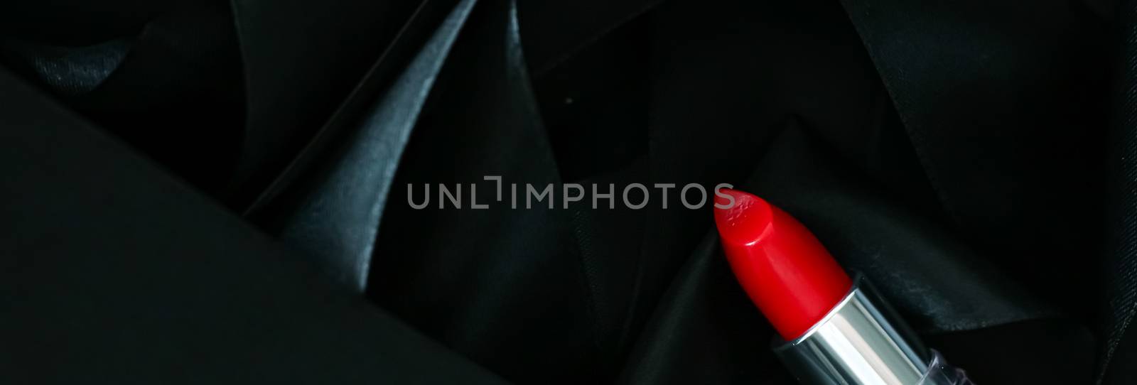 Red lipstick on black silk background, luxury make-up and beauty cosmetics