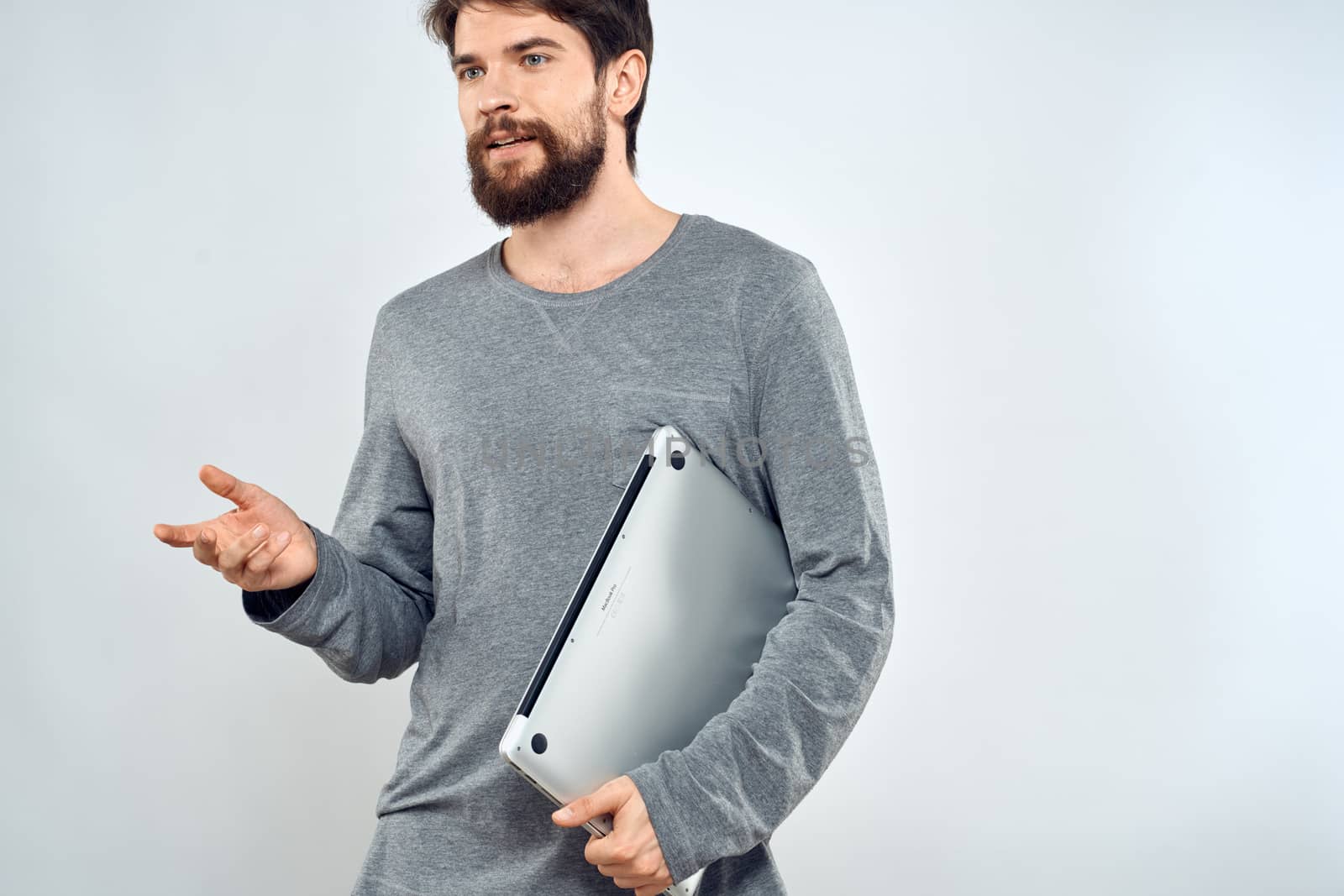 Emotional man holding a laptop success modern style work light background by SHOTPRIME
