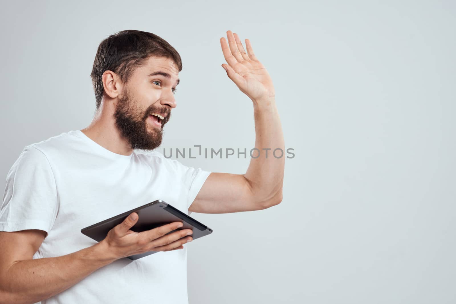 emotional man with tablet in hand touch screen new technologies light background cropped view Copy Space. High quality photo