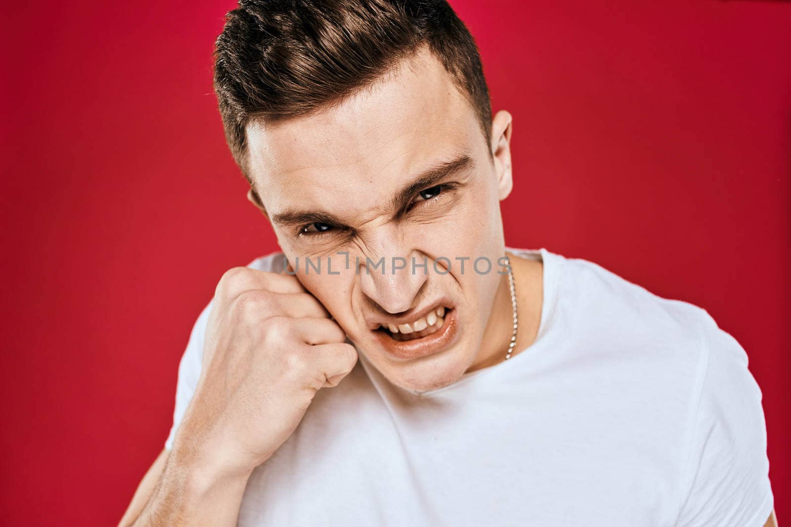 Man in white t-shirt emotions displeased facial expression isolated background. High quality photo