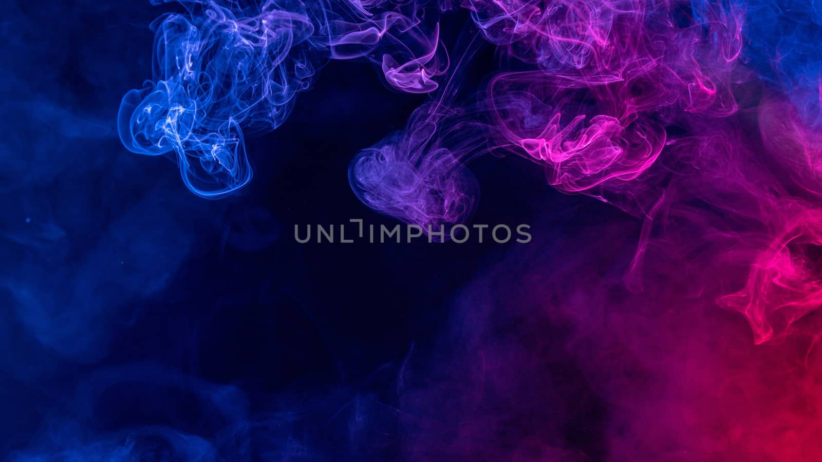 Conceptual image of colorful red and blue color smoke isolated on dark black background, Halloween concept design element.
