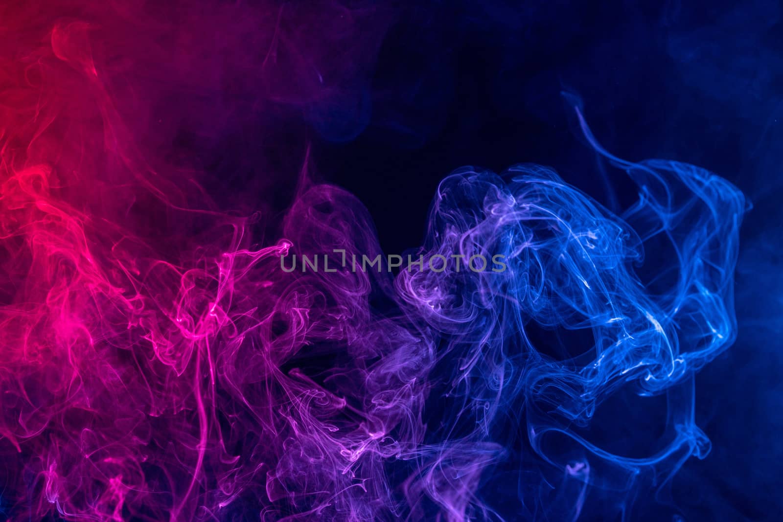 Conceptual image of colorful red and blue color smoke isolated on dark black background, Halloween concept design element.