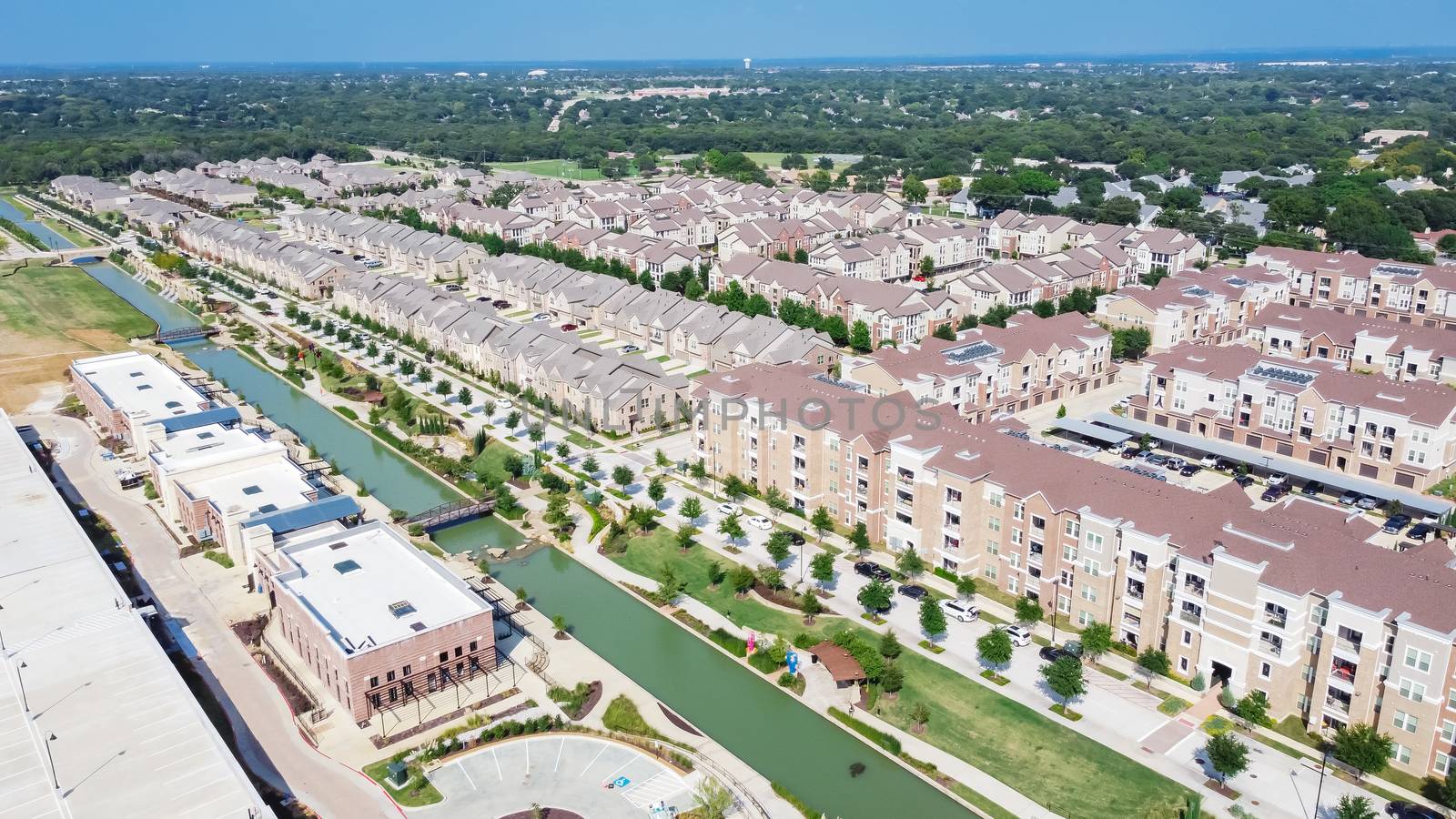 Aerial view of brand new riverside two story condo, townhomes and apartment complex in downtown Flower Mound, Texas, US. Master-planned community and census-designated residential houses