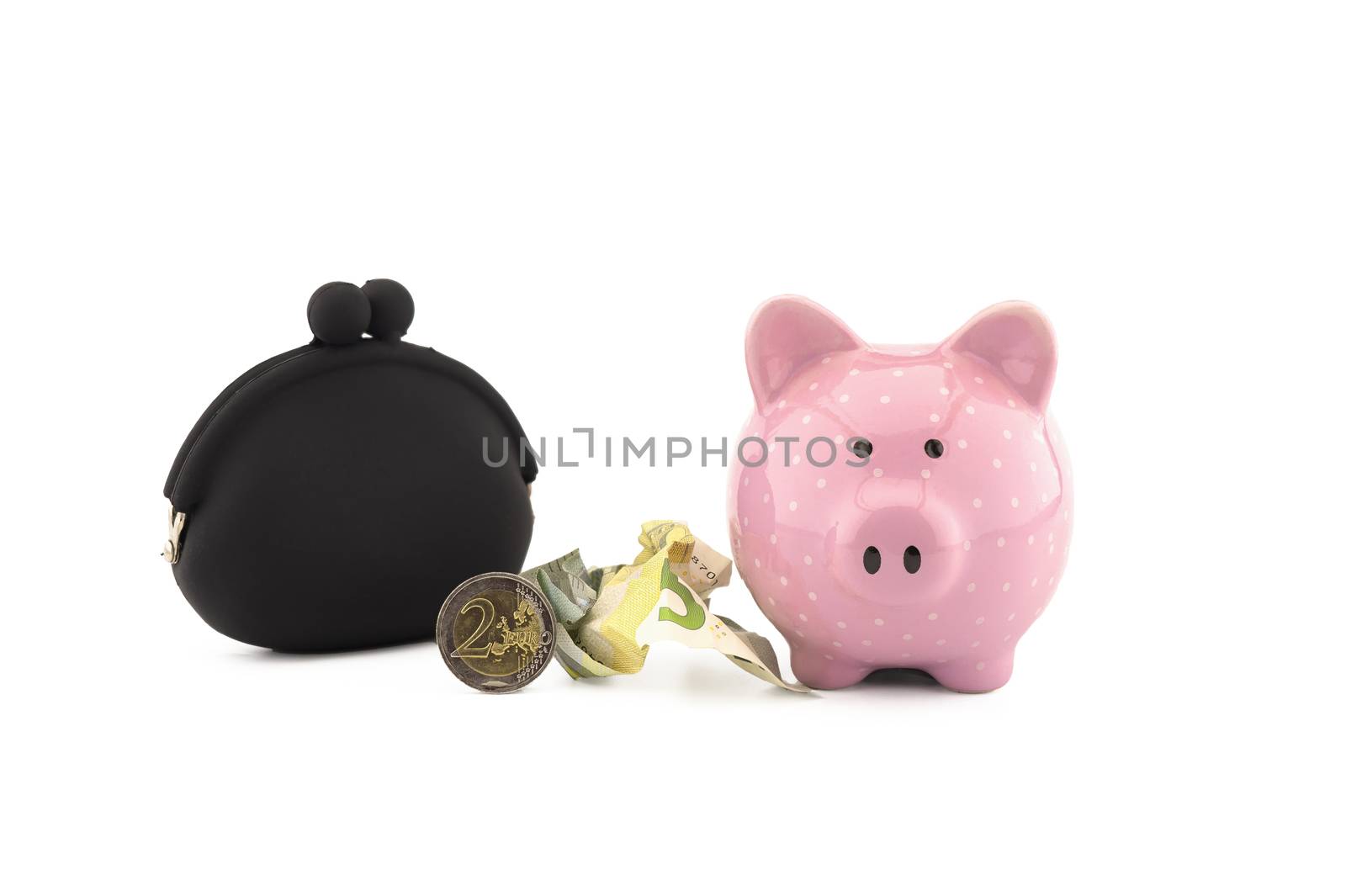 Black retro purse alongside crumpled banknotes, coins and cute pink piggy bank on white with copyspace for financial or savings concepts