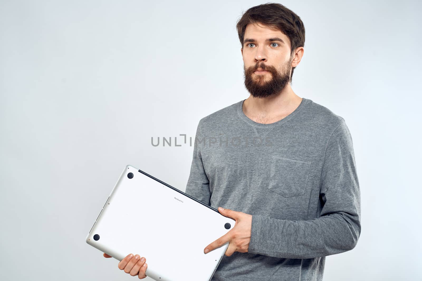 Emotional man holding a laptop success modern style work light background. High quality photo