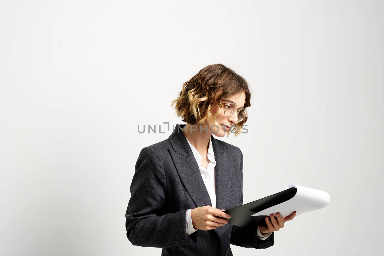 business woman in a suit with documents in hands light background curly hair hairstyle. High quality photo