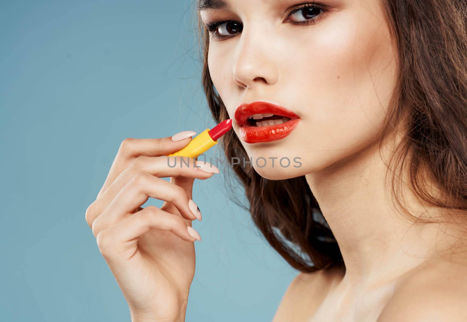 Sexy brunette with bright makeup and lipstick blue background by SHOTPRIME