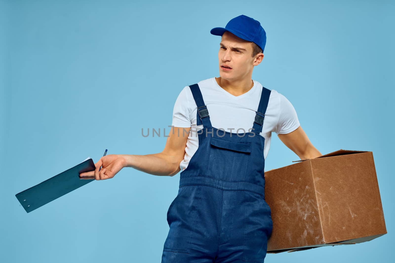 Man worker with cardboard box delivery loader lifestyle blue background. High quality photo