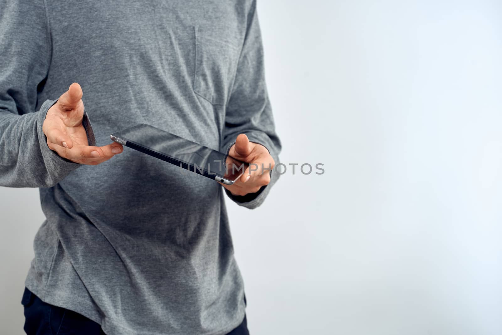 Man with tablet in hands technology lifestyle internet communication work light background cropped view by SHOTPRIME