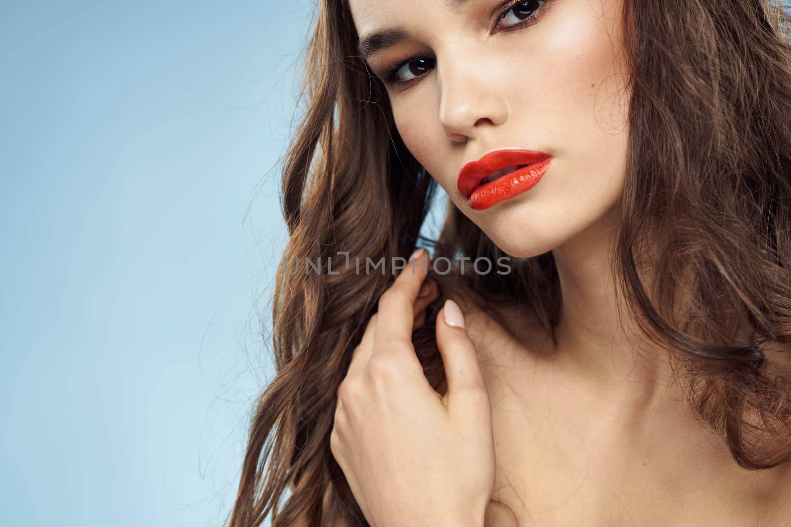 Beautiful woman naked shoulders hairstyle care bright makeup blue background. High quality photo