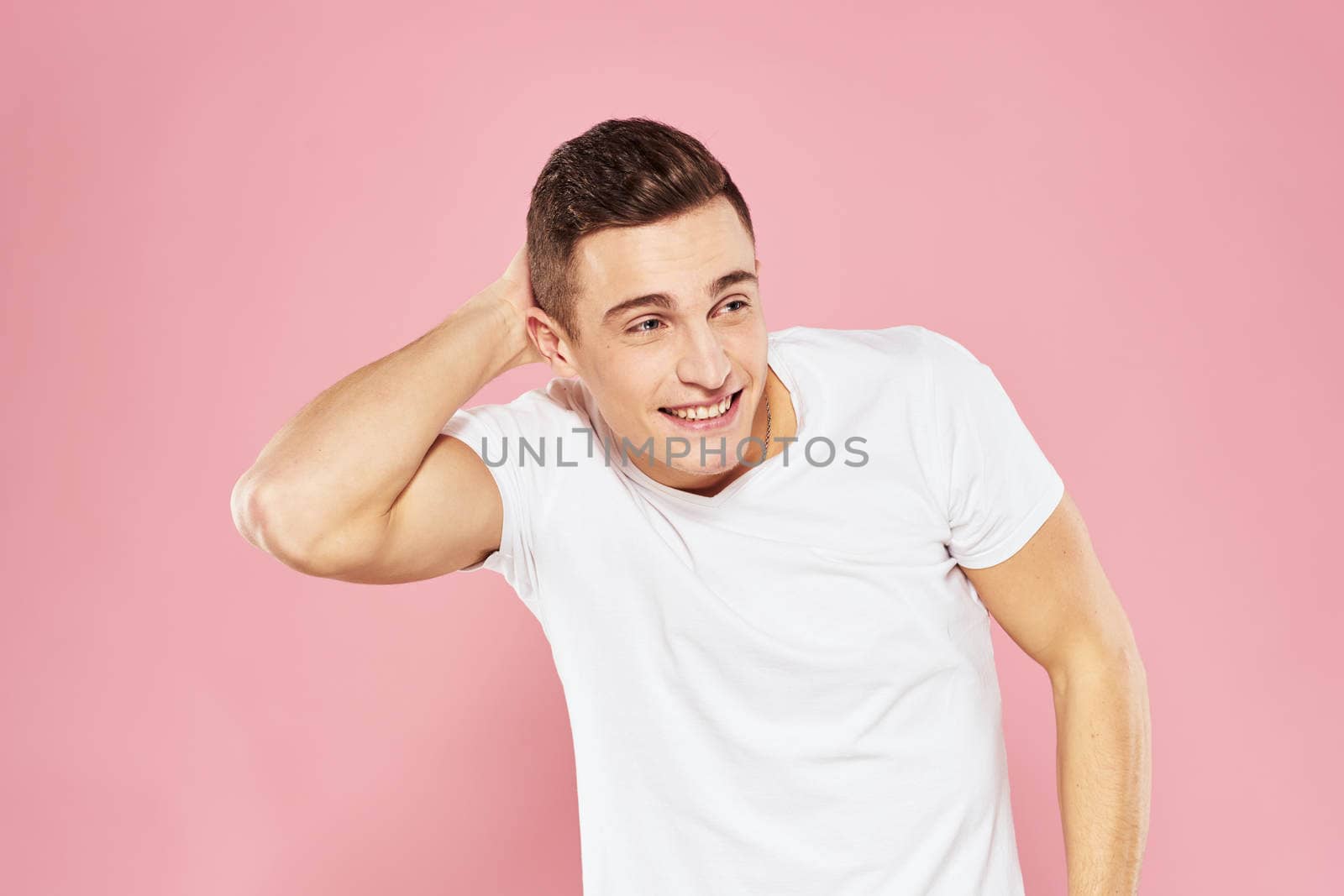 Cheerful handsome man in white t-shirt emotions pink isolated background by SHOTPRIME