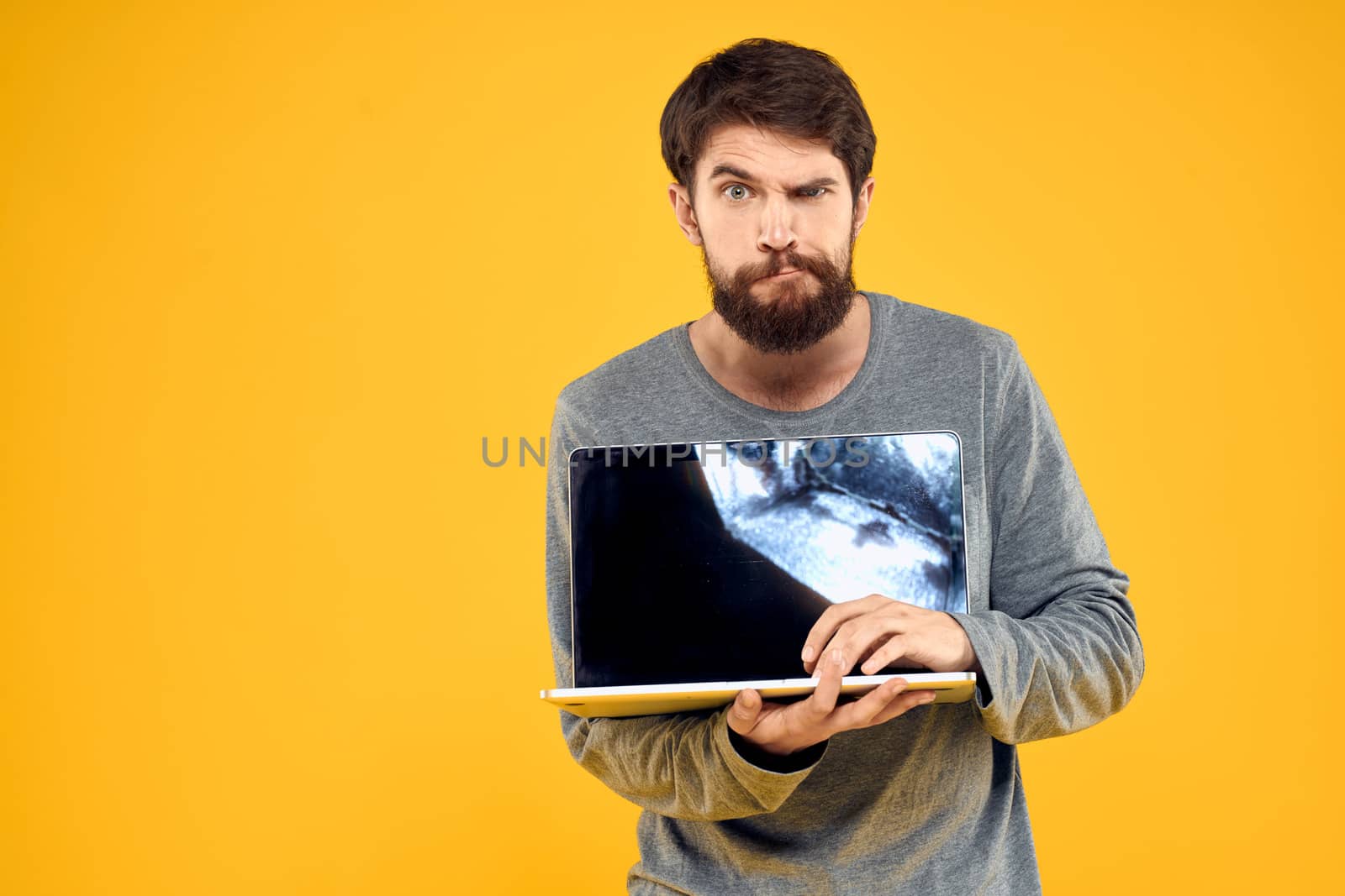 man with laptop wireless technology internet lifestyle work yellow isolated background by SHOTPRIME